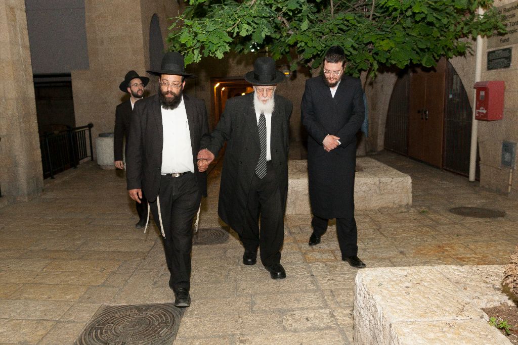 Senior rabbi escorted by organization members